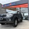toyota-awt-fortuner-suv-todo-terreno-gasolina-4x4-tm-manual-7-pasajeros-3-filas-2011-plomo-halogenos-retrovisores-cromados-barra-de-tiro-sensores-de-parqueo-aleron-4-vidrios-y-retrovisores-electricos-alarma-bloqueo-central-airbags-asientos-de-cuero-radio-original-bluetooth-aux-usb-aire-acondicionado-bizona-frenos-de-disco-abs