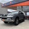 suv-todo-terreno-4x4-7-pasajeros-gasolina-toyota-fortuner-4.0-ta-transimision-automatica-plateado-2018-full-barra-de-tiro-halogenos-neblineros-faros-led-con-regulador-de-altura-mascarilla-cromada-aros-deportivos-toyota-parrilla-retrovisores-electricos-cromados-abatibles-con-direccionales-compuerta-electrica-estribos-sensores-de-parqueo-aleron-pantalla-camara-de-retro-asientos-de-cuero-paletas-de-cambios-al-volante-mandos-de-audio-y-velocidad-al-volante-bloqueo-central-alarma-airbags-aire-acondicionado-bizona-ac-3-filas-asientos-placas-azuay-segundo-dueño-control-de-estabilidad-modos-de-manejo-boton-de-encendido-dos-radiollaves-toyota-volante-y-puertas-con-cuero